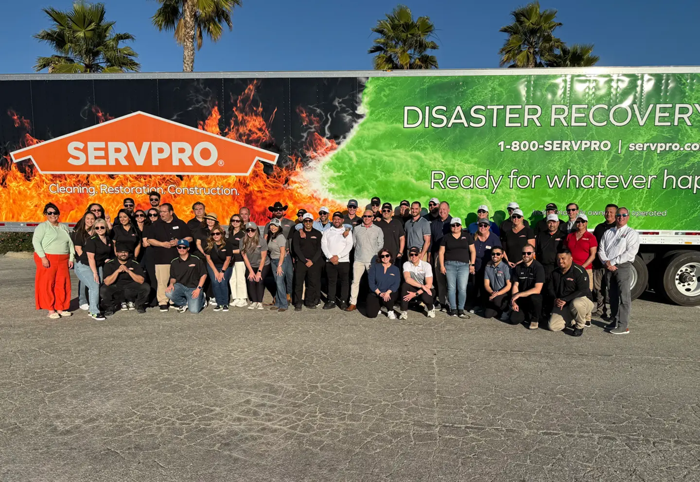 Volunteers from Southern California SERVPRO franchises gather in front of a SERVPRO trailer at a wildfire relief event